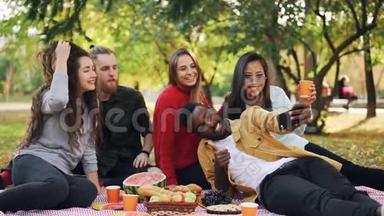 快乐的非裔美国人用智能手机和朋友在野餐时自拍的动作很慢，人们正在和